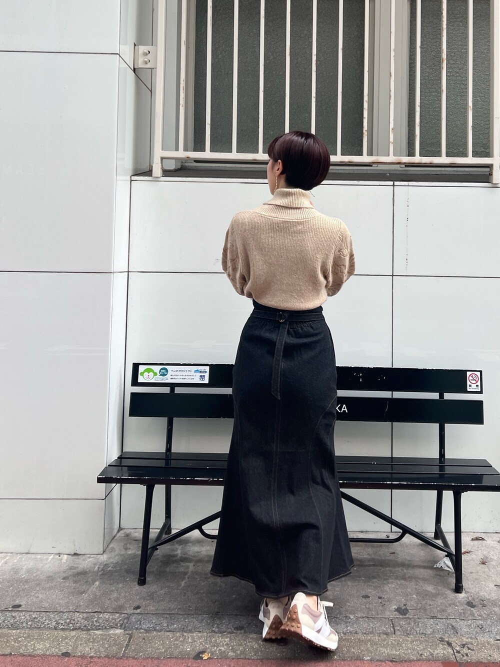 ベージュ系のスニーカー、グリーン系のカーディガン/ボレロ、ブラック系のデニムスカートを着用したレディースの秋コーディネートの7枚目の写真