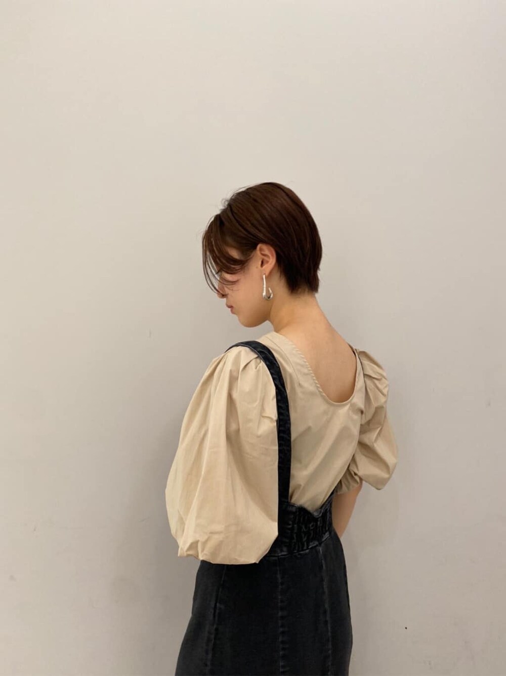 ベージュ系のシャツ/ブラウス、ブラック系のスカート、ベージュ系のブーツを着用したレディースの夏コーディネートの3枚目の写真