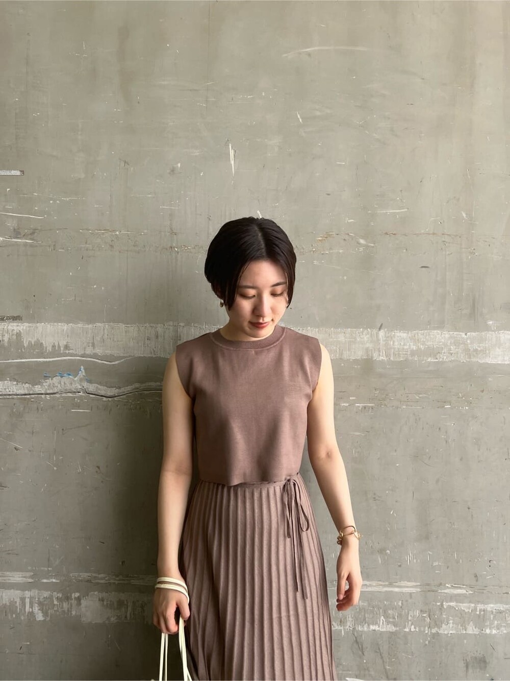 ホワイト系のハンドバッグ、ホワイト系のサンダル、ブラウン系のワンピースを着用したレディースの夏コーディネートの4枚目の写真