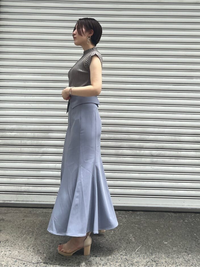 ベージュ系のハンドバッグ、その他のパンプス、ブルー系のスカートを着用したレディースの夏コーディネートの2枚目の写真