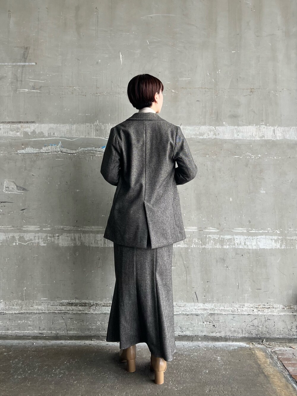 ブラウン系のスカート、ブラウン系のテーラードジャケット、ホワイト系のハンドバッグを着用したレディースの秋コーディネートの3枚目の写真