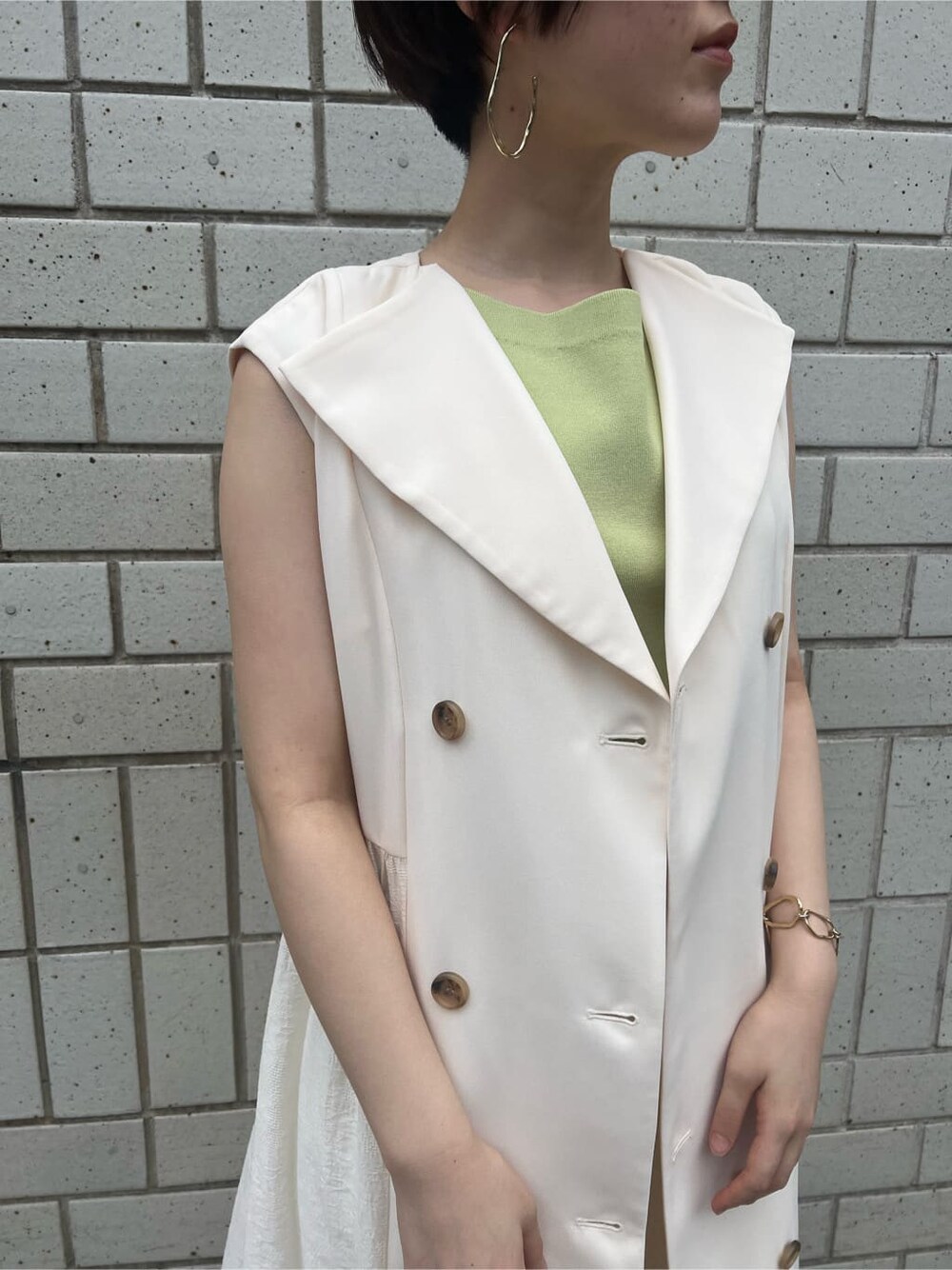 ホワイト系のハンドバッグ、ホワイト系のワンピース、グリーン系のサンダルを着用したレディースの春コーディネートの4枚目の写真