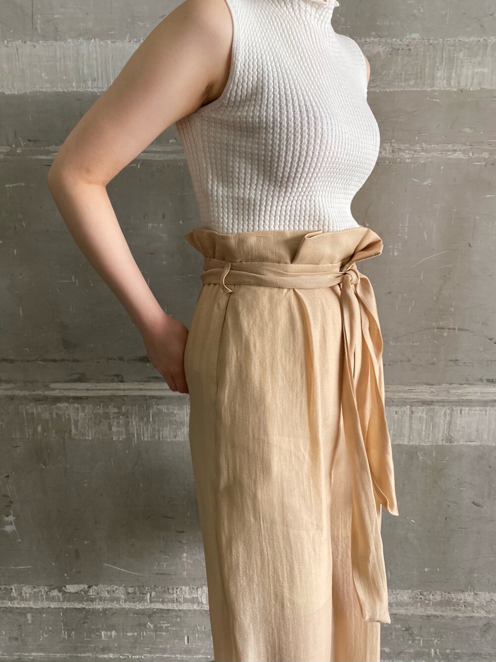 その他のその他シューズ、ベージュ系のその他パンツ、ゴールド系のハンドバッグを着用したレディースの春コーディネートの2枚目の写真