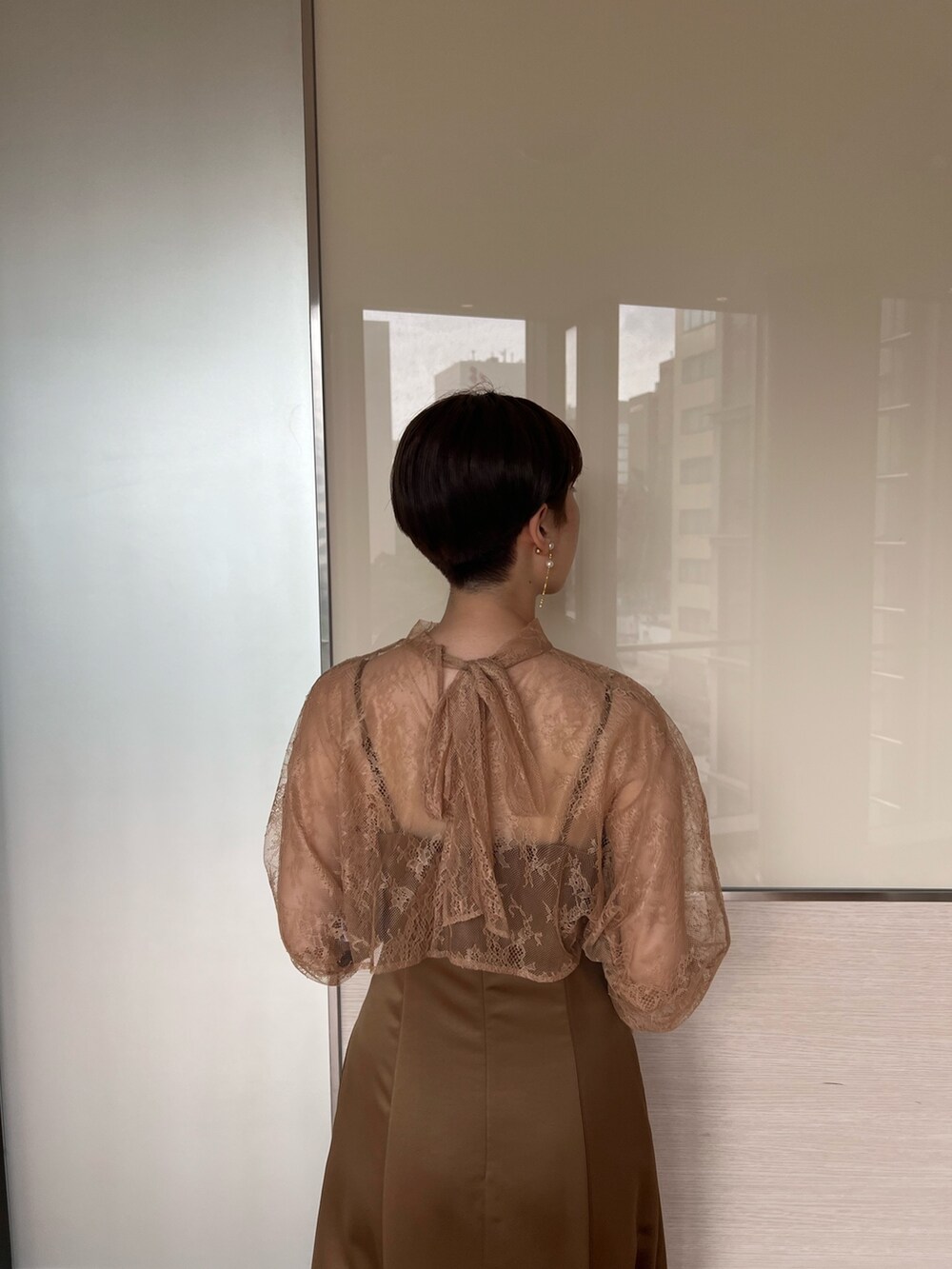 ベージュ系のクラッチバッグ、ブラウン系のドレス、ベージュ系のパンプスを着用したレディースの夏コーディネートの4枚目の写真