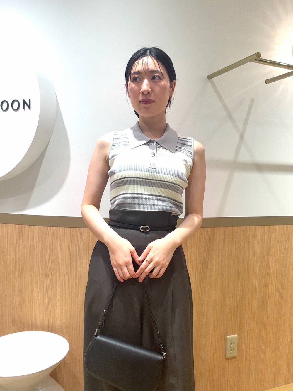 グレー系のニット/セーター、グレー系のその他パンツ、ブラック系のハンドバッグを着用したレディースの春コーディネートの4枚目の写真