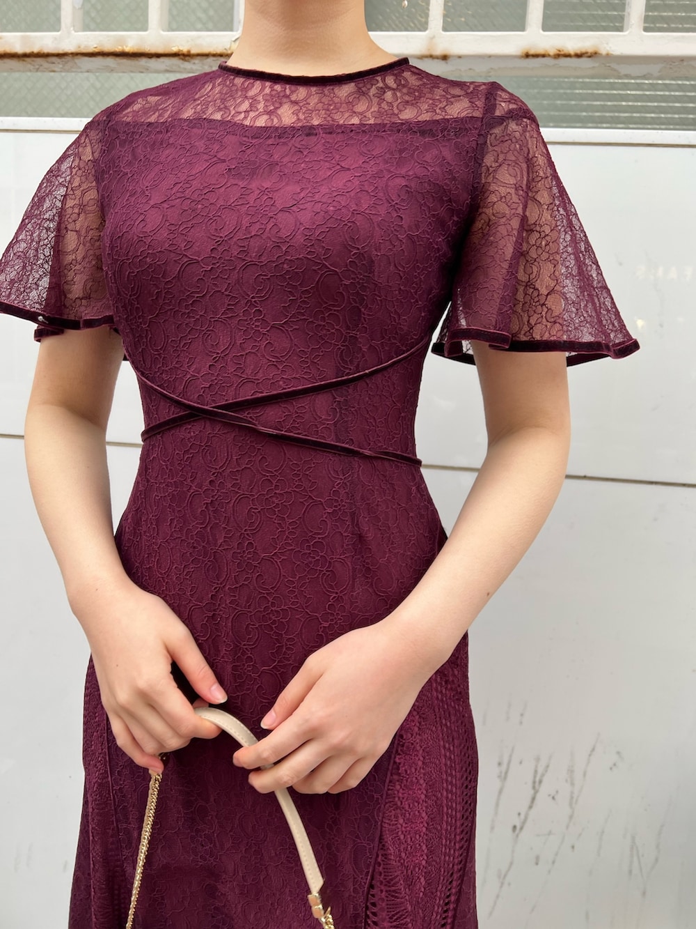ホワイト系のノーカラーコート、レッド系のドレス、ベージュ系のパンプスを着用したレディースの冬コーディネートの8枚目の写真