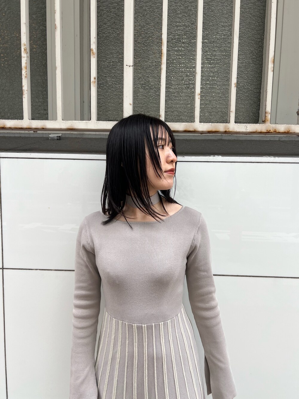 ホワイト系のブルゾン、グレー系のワンピース、ホワイト系のハンドバッグを着用したレディースの冬コーディネートの10枚目の写真