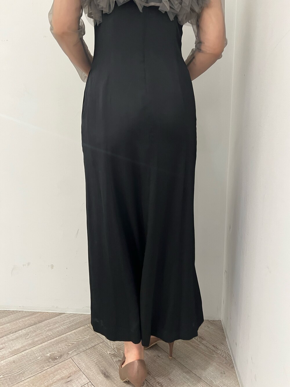 グレー系のドレス、ゴールド系のクラッチバッグ、ゴールド系のパンプスを着用したレディースの春コーディネートの7枚目の写真