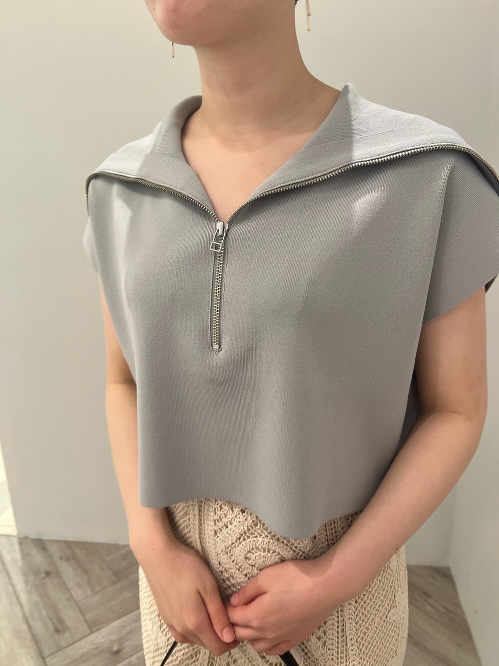 ベージュ系のサンダル、ブラック系のハンドバッグ、ブルー系のニット/セーターを着用したレディースの春コーディネートの3枚目の写真