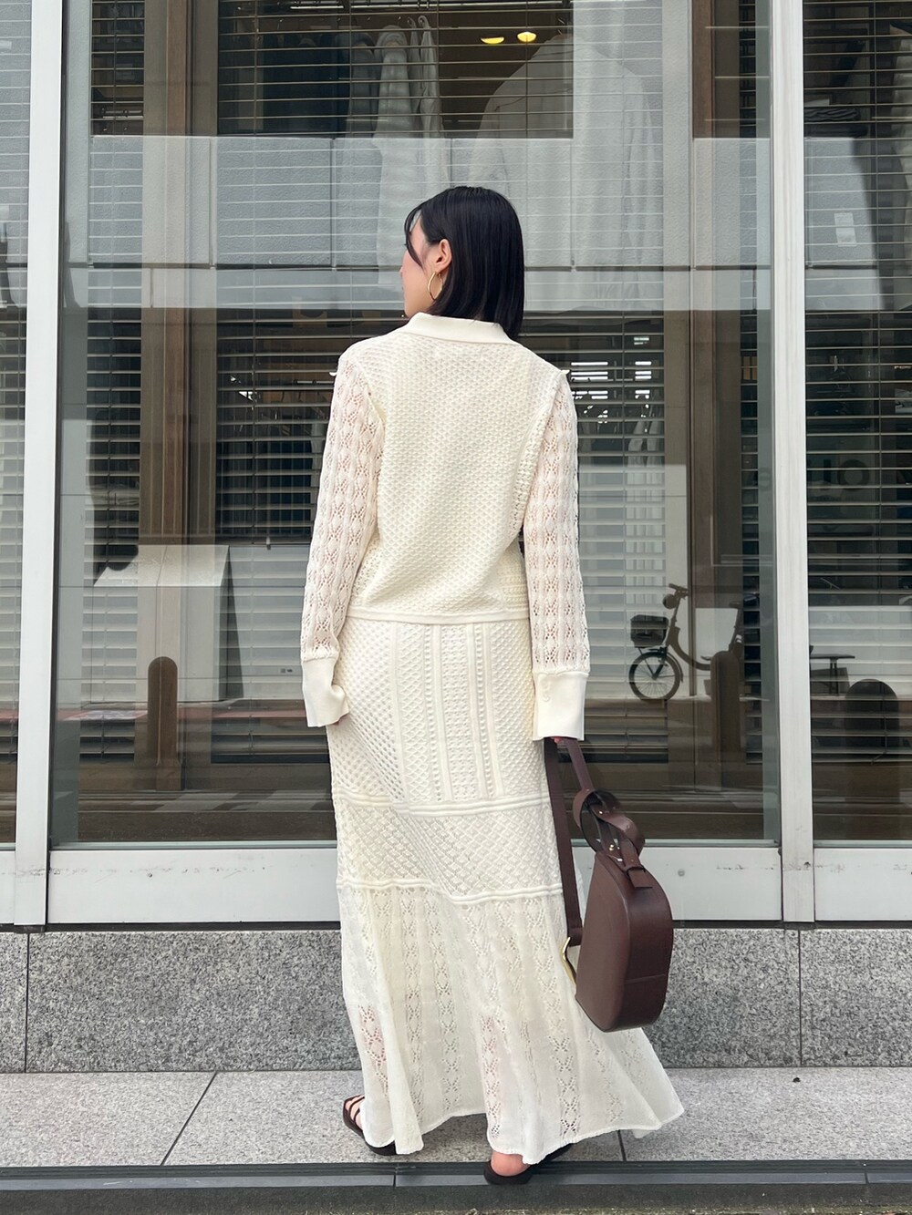 ブラウン系のショルダーバッグ、ホワイト系のカーディガン/ボレロ、ホワイト系のTシャツ/カットソーを着用したレディースの春コーディネートの3枚目の写真