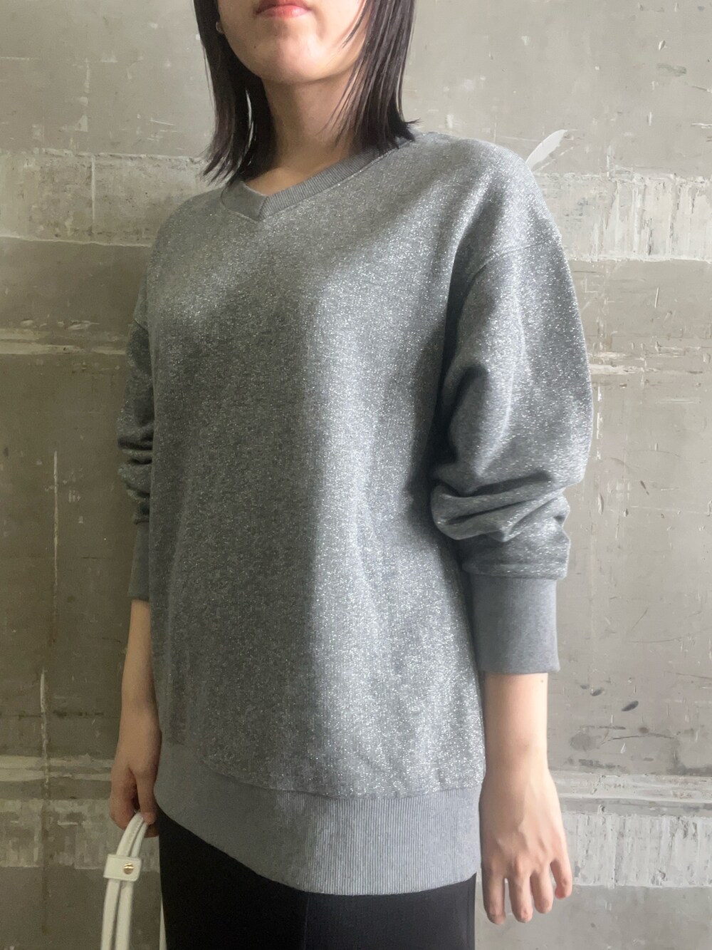 ブラック系のスカート、ブラック系のブーツ、グレー系のスウェットを着用したレディースの秋コーディネートの4枚目の写真