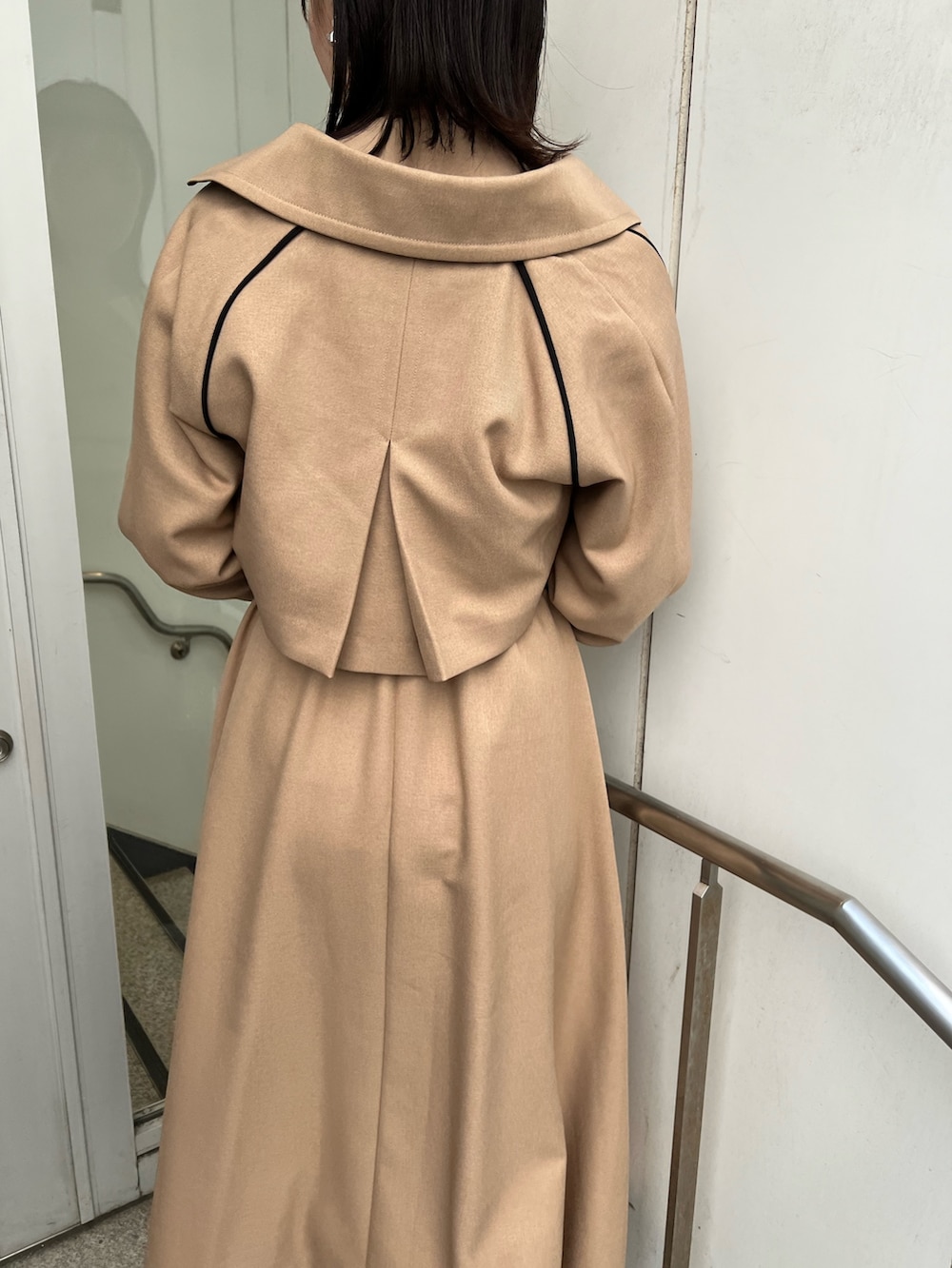 ベージュ系のトレンチコート、ホワイト系のショルダーバッグ、ホワイト系のニット/セーターを着用したレディースの秋コーディネートの5枚目の写真