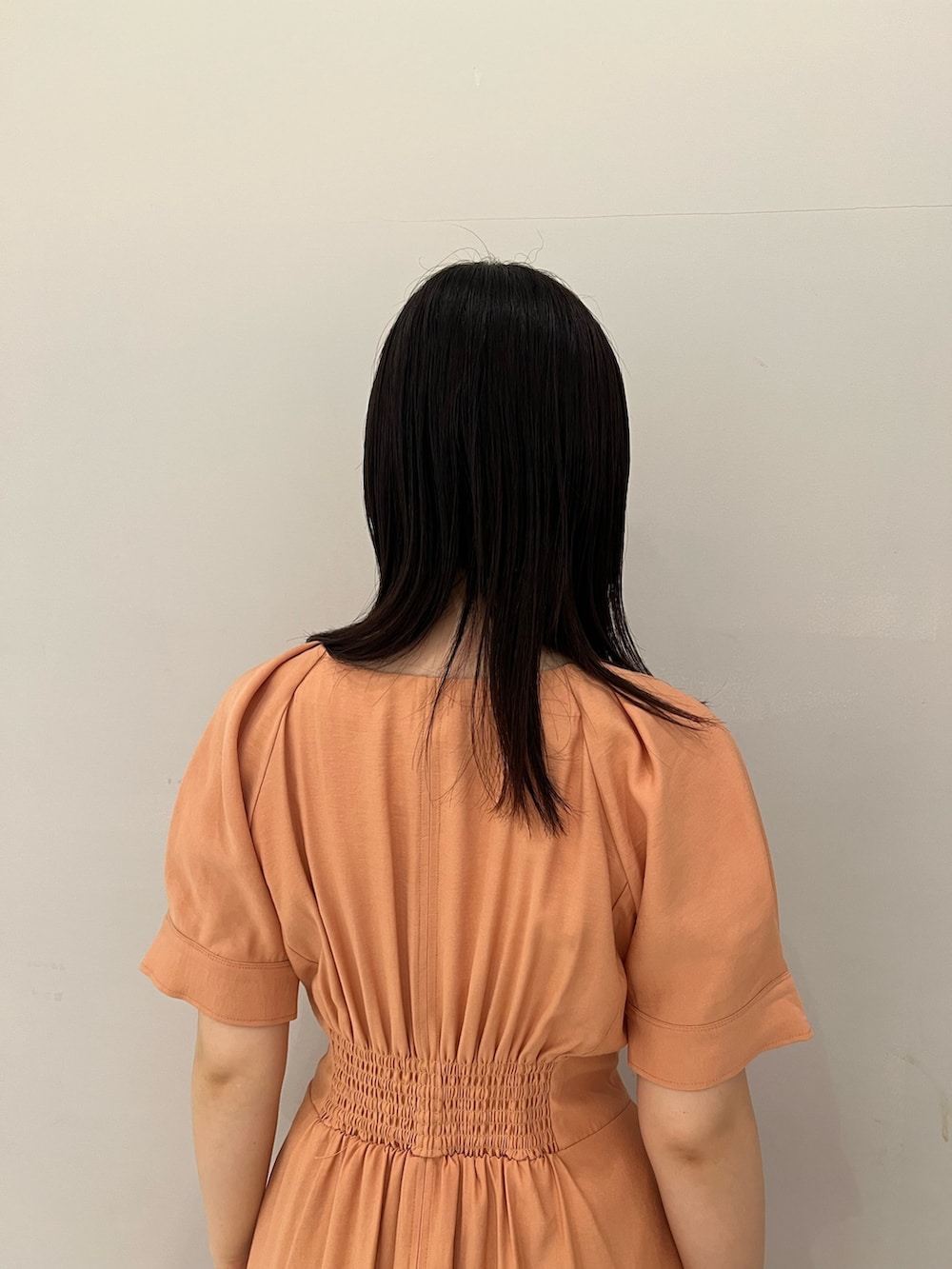 オレンジ系のワンピース、ホワイト系のサンダルを着用したレディースの春コーディネートの6枚目の写真