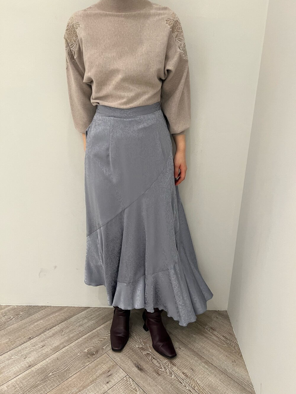 ブルー系のスカート、レッド系のブーツ、グレー系のニット/セーターを着用したレディースの冬コーディネートの5枚目の写真