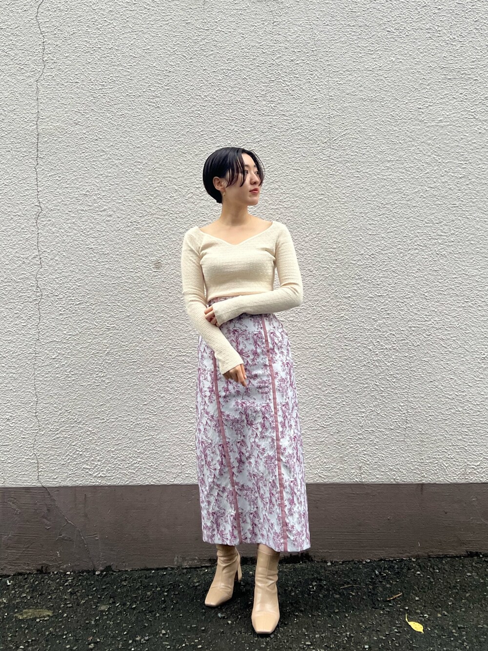 ベージュ系のブーツ、ベージュ系のその他アウター、ホワイト系のニット/セーターを着用したレディースの秋コーディネートの4枚目の写真