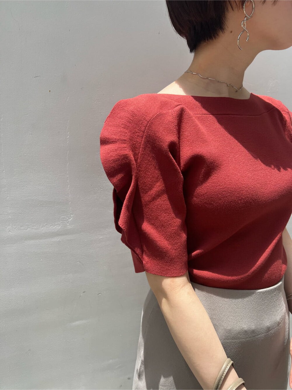 ベージュ系のハンドバッグ、ホワイト系のサンダル、ベージュ系のスカートを着用したレディースの夏コーディネートの4枚目の写真