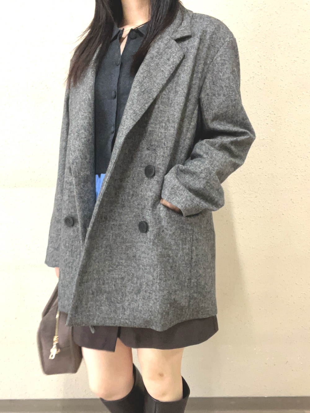 ブラウン系のブーツ、ブラック系のスカート、グレー系のテーラードジャケットを着用したレディースの秋コーディネートの4枚目の写真