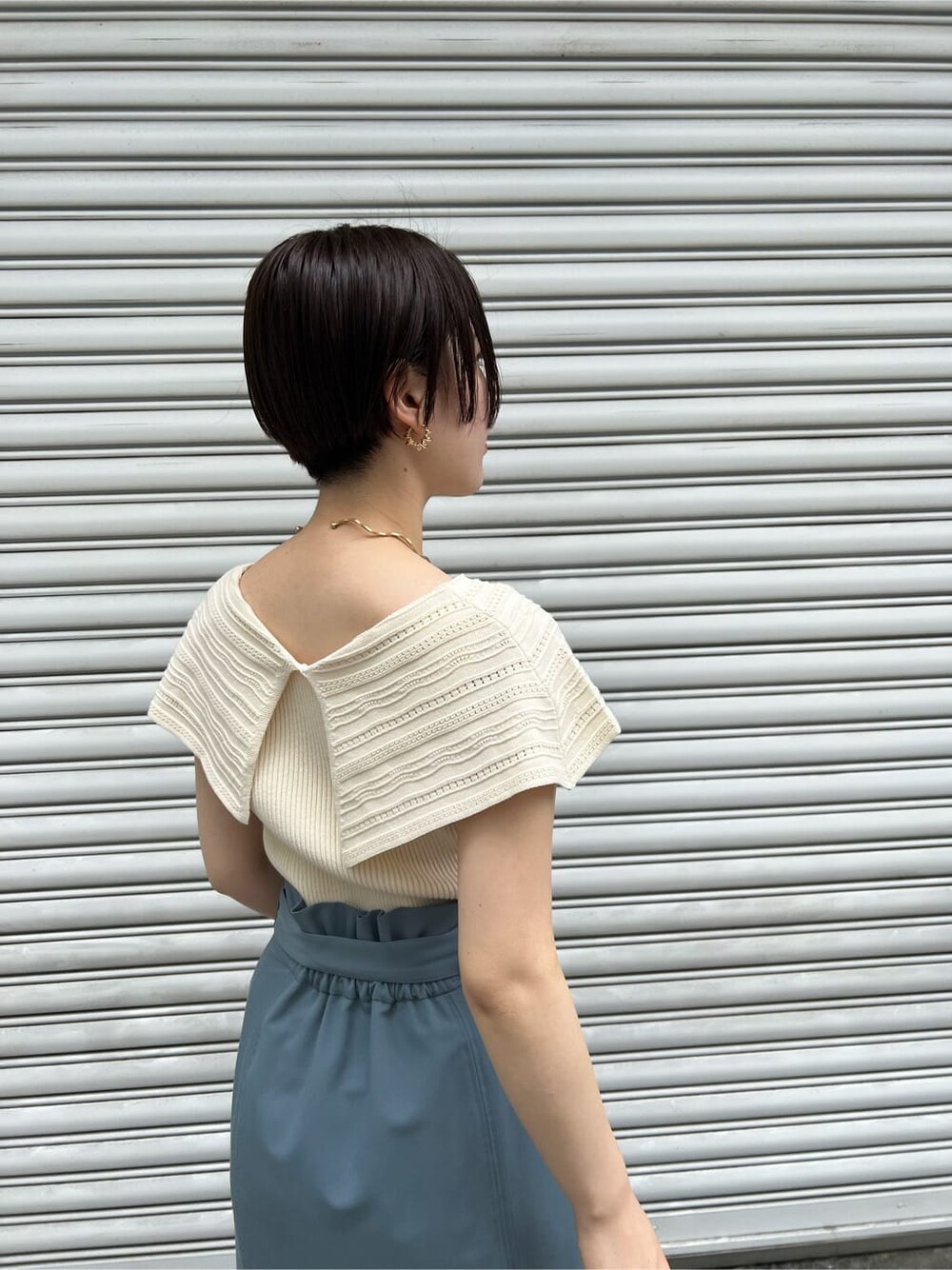 その他のパンプス、ホワイト系のショルダーバッグ、ブルー系のスカートを着用したレディースの春コーディネートの6枚目の写真