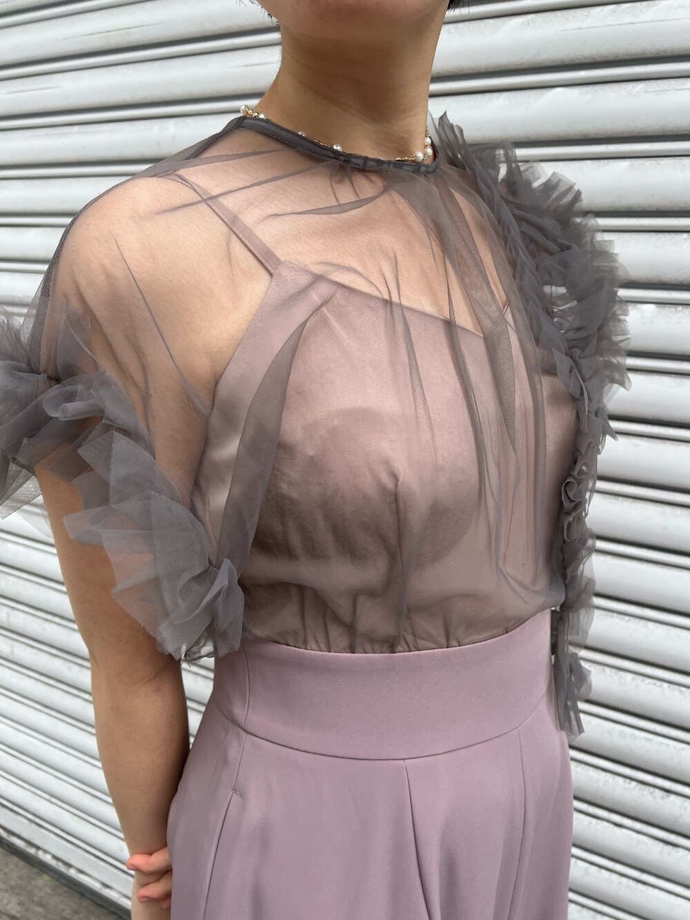 シルバー系のパンプス、ブラック系のチェスターコート、シルバー系のハンドバッグを着用したレディースの冬コーディネートの7枚目の写真