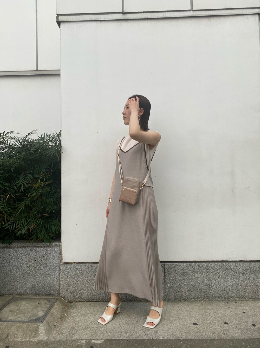 ホワイト系のサンダル、ベージュ系のワンピース、ホワイト系のニット/セーターを着用したレディースの春コーディネートの2枚目の写真