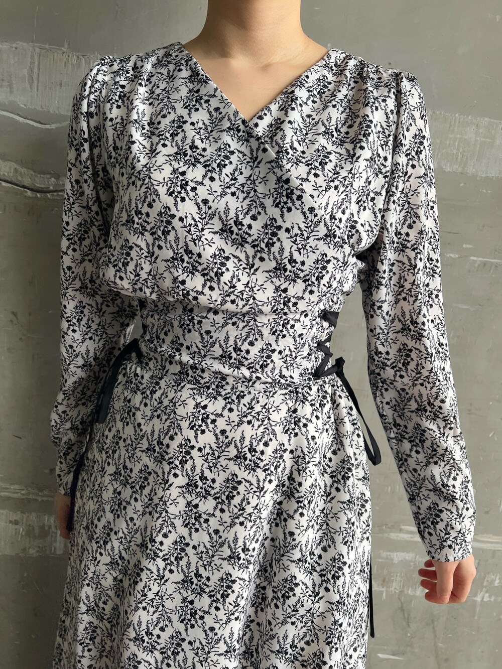 ベージュ系のブーツ、ブラック系のその他アウター、ホワイト系のワンピースを着用したレディースの冬コーディネートの7枚目の写真