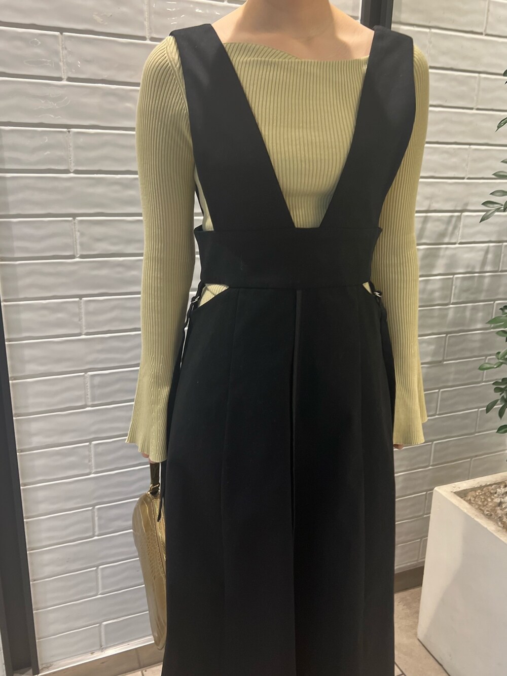 ベージュ系のブーツ、グリーン系のニット/セーター、ベージュ系のハンドバッグを着用したレディースの冬コーディネートの5枚目の写真