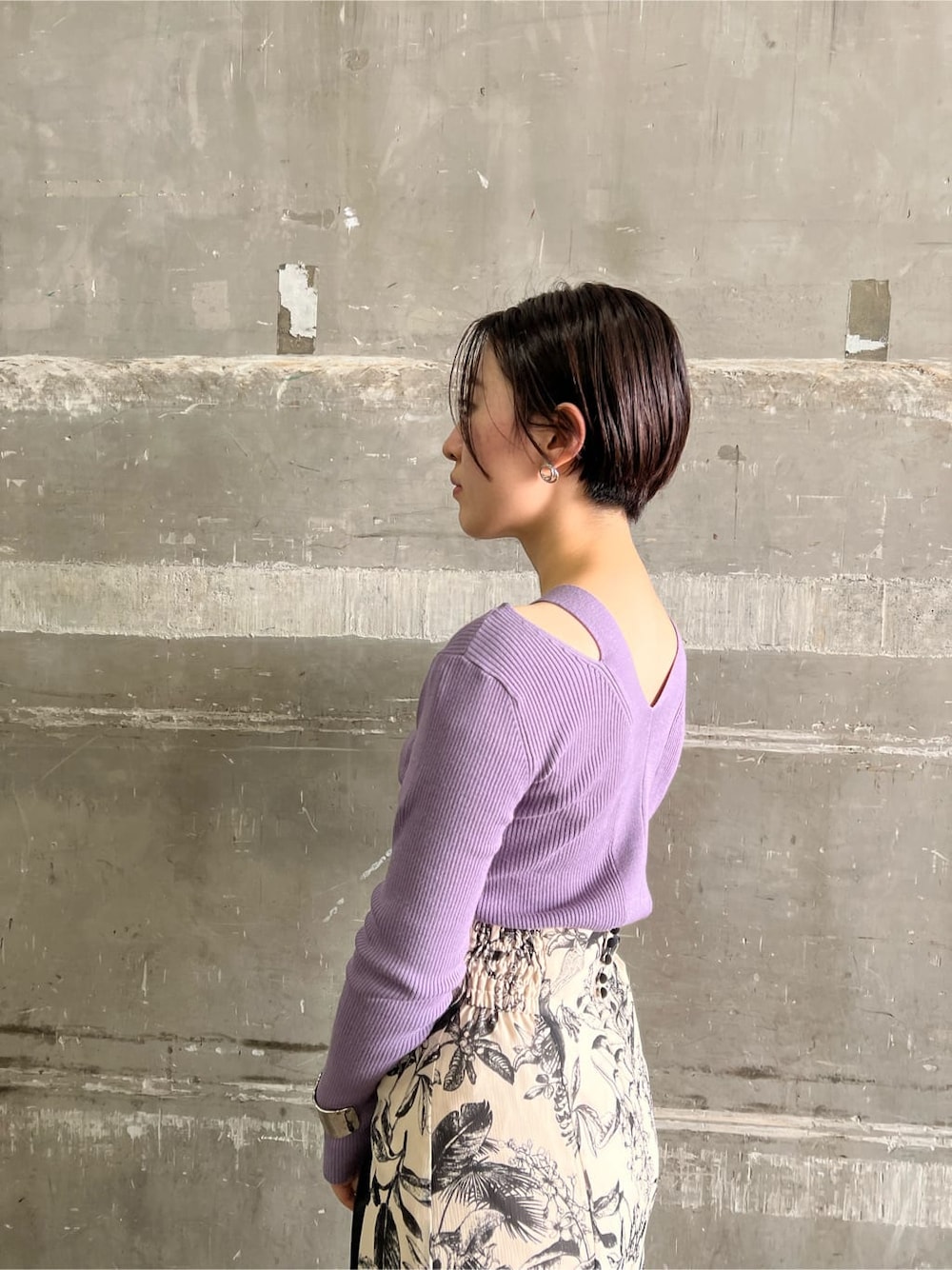 ベージュ系のスカート、ブラック系のブーツ、パープル系のニット/セーターを着用したレディースの秋コーディネートの5枚目の写真