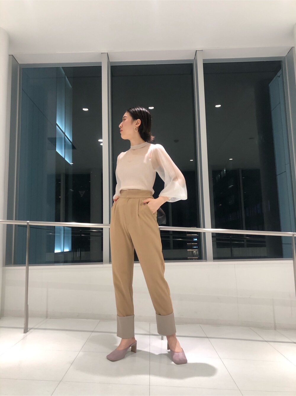 ベージュ系のその他アウター、パープル系のサンダル、パープル系のハンドバッグを着用したレディースの冬コーディネートの4枚目の写真