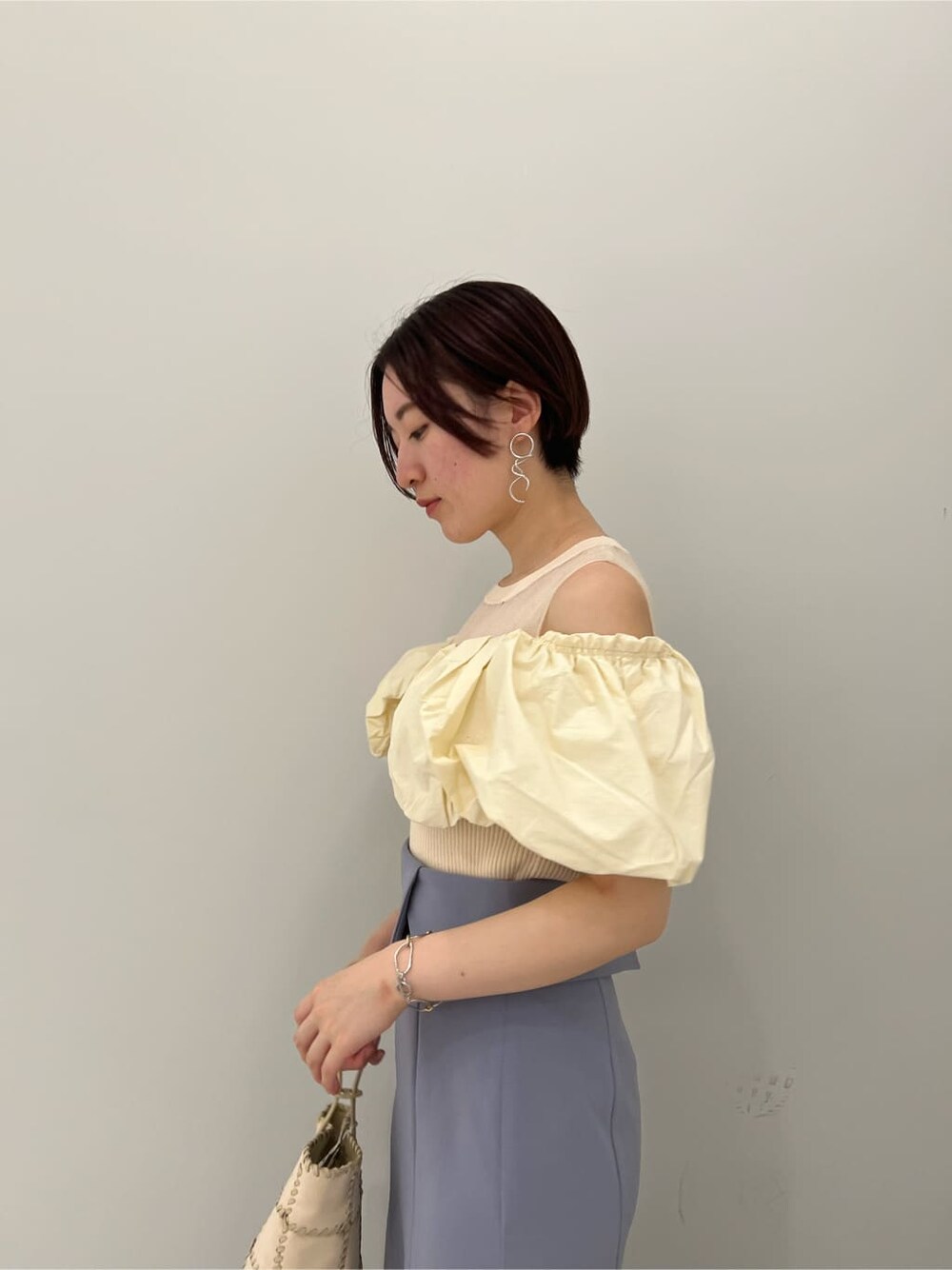 その他のパンプス、ホワイト系のショルダーバッグ、ホワイト系のニット/セーターを着用したレディースの夏コーディネートの5枚目の写真