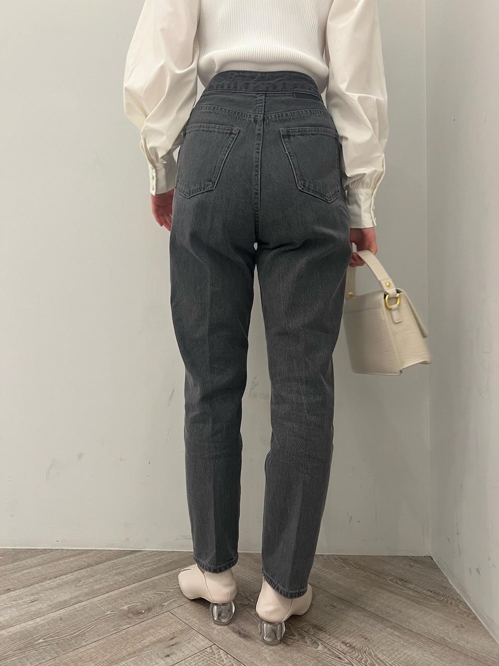 ホワイト系のトレンチコート、ホワイト系のニット/セーター、ブラック系のデニムパンツを着用したレディースの冬コーディネートの9枚目の写真