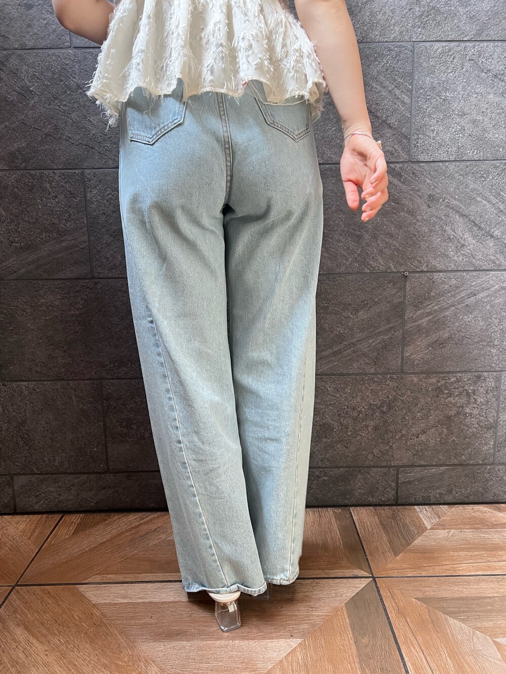 ホワイト系のサンダル、ホワイト系のキャミソール、ブルー系のデニムパンツを着用したレディースの夏コーディネートの7枚目の写真