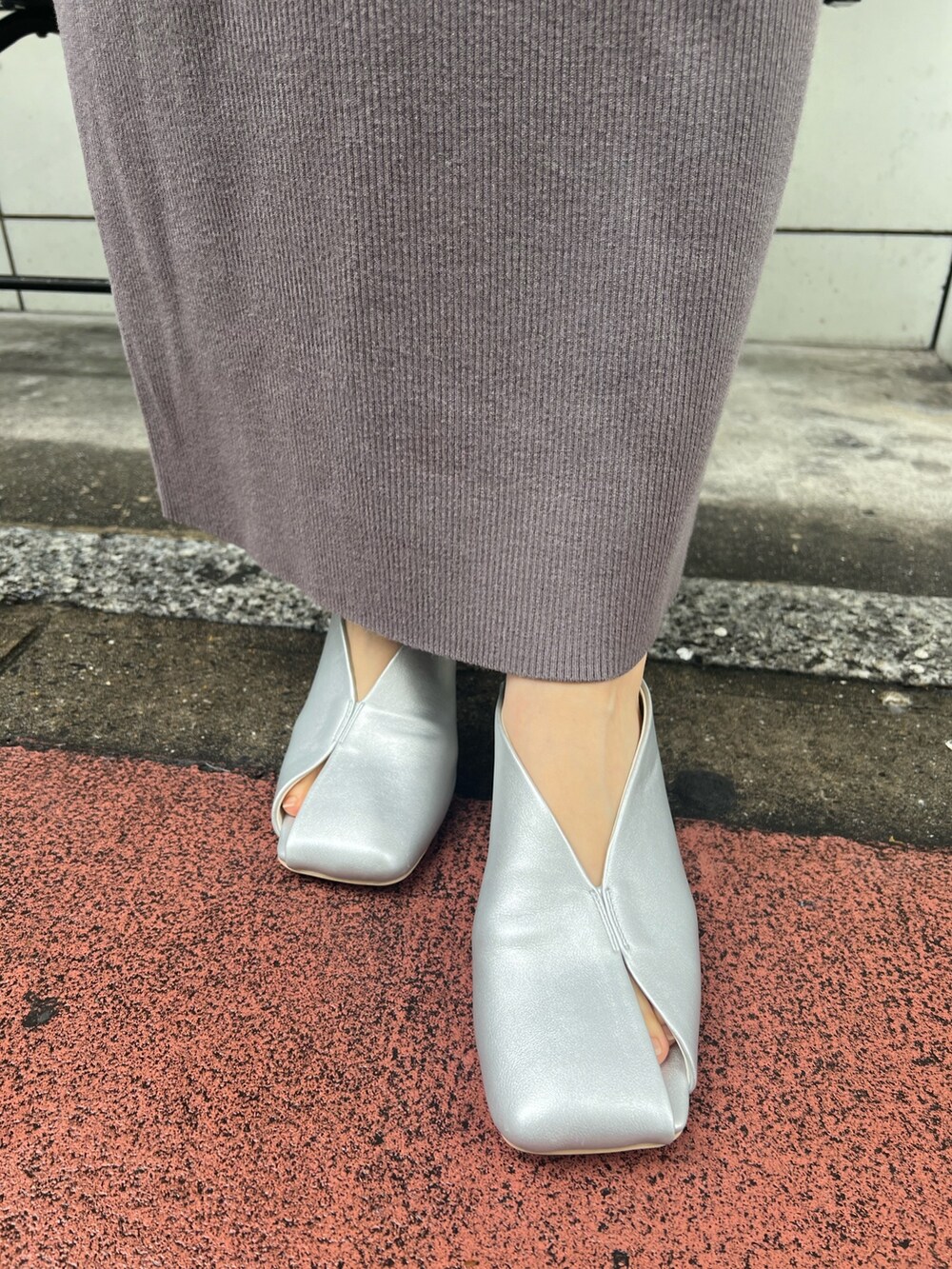 ブラック系のハンドバッグ、グレー系のワンピース、シルバー系のパンプスを着用したレディースの冬コーディネートの7枚目の写真