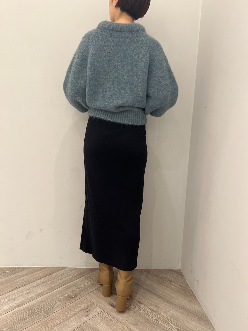 ベージュ系のブーツ、ブラック系のスカート、グリーン系のニット/セーターを着用したレディースの冬コーディネートの9枚目の写真