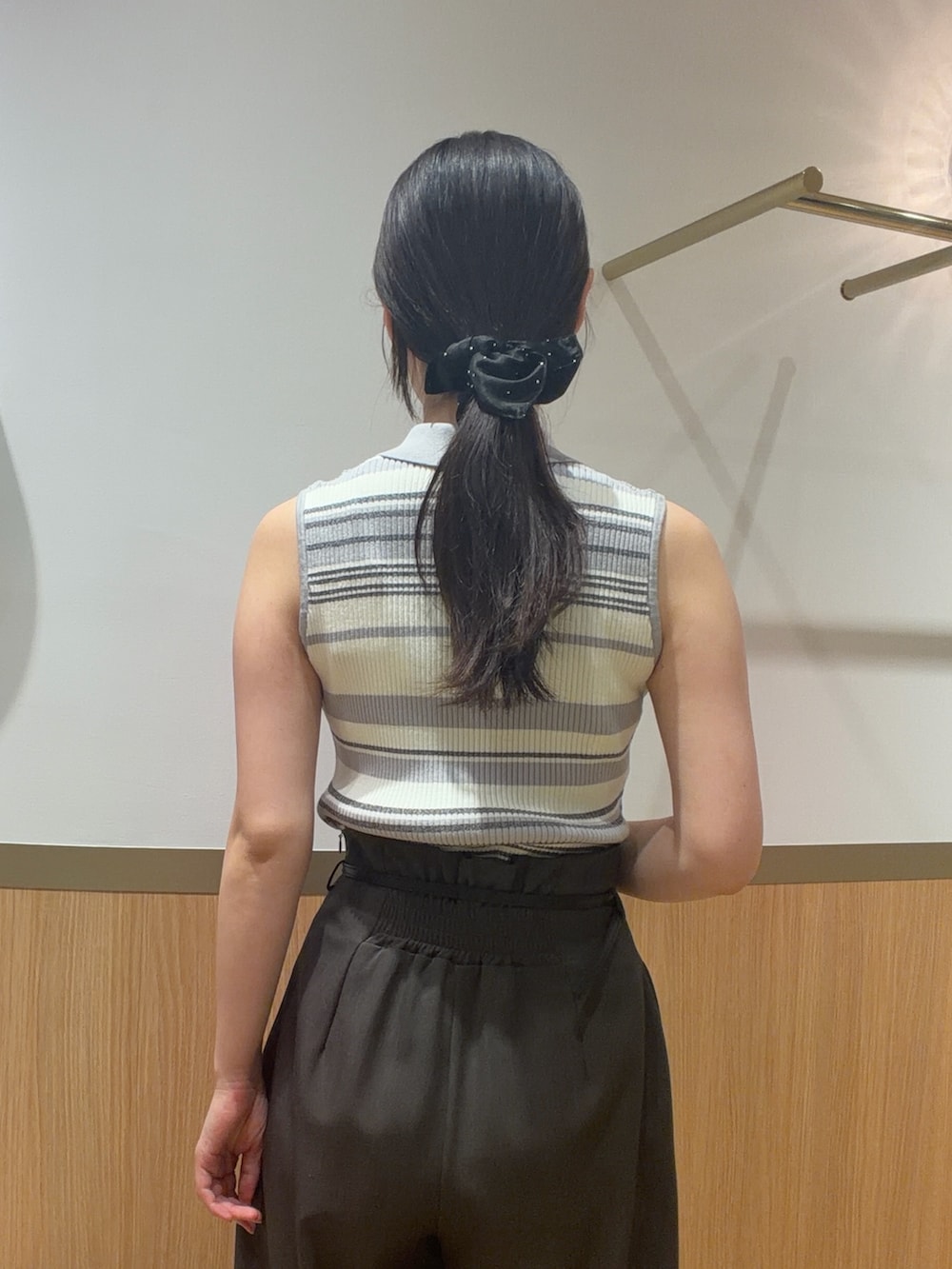 グレー系のニット/セーター、グレー系のその他パンツ、ブラック系のハンドバッグを着用したレディースの春コーディネートの6枚目の写真