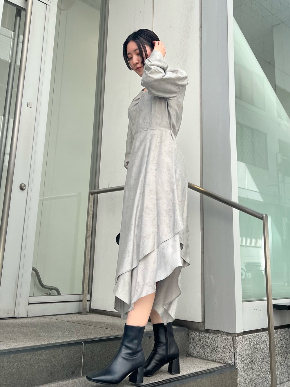 グレー系のカーディガン/ボレロ、グレー系のワンピース、ブラック系のブーツを着用したレディースの秋コーディネートの5枚目の写真