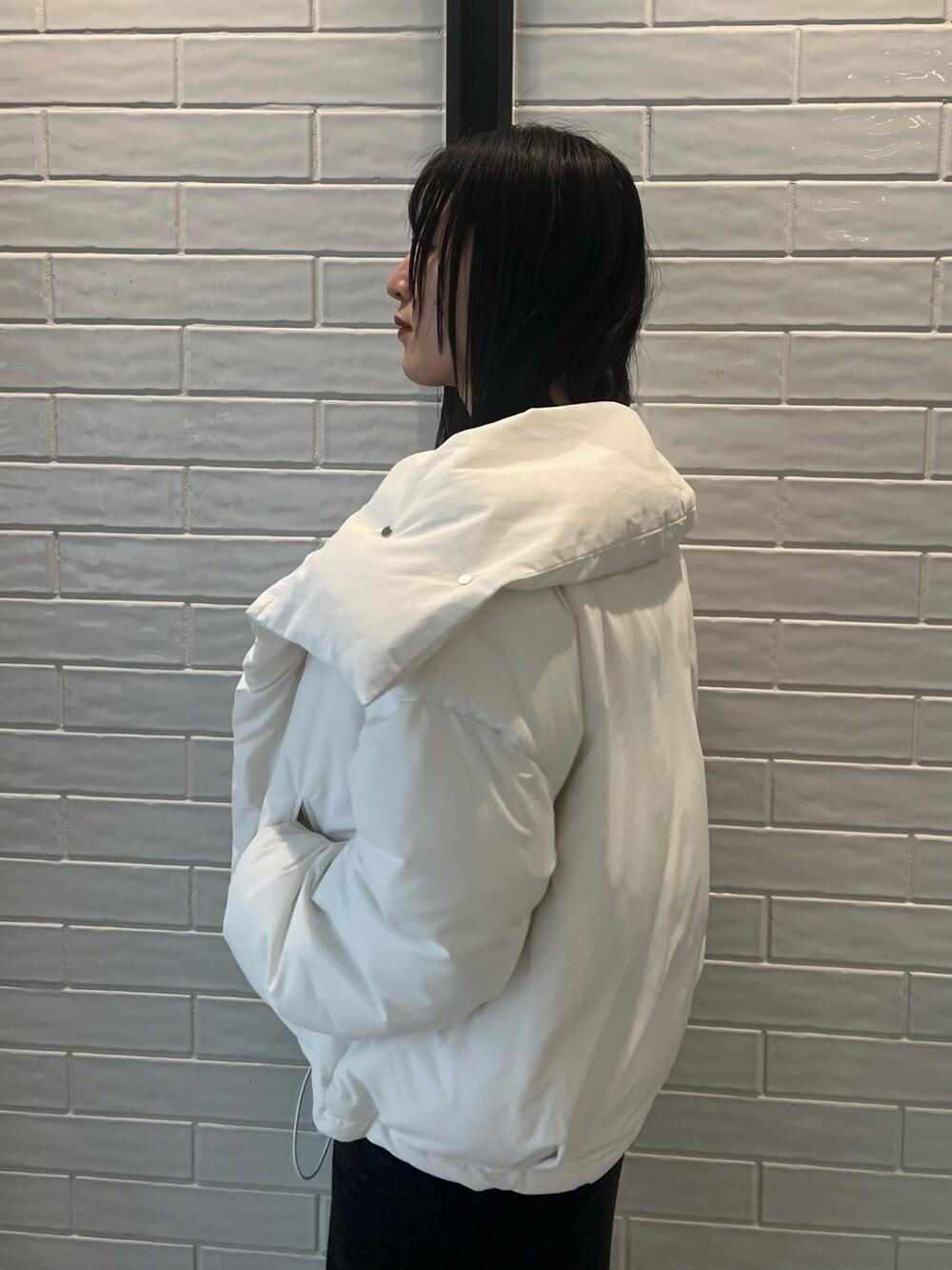 ホワイト系のダウンジャケット/コート、ブラック系のワンピース、ブラック系のブーツを着用したレディースの冬コーディネートの5枚目の写真