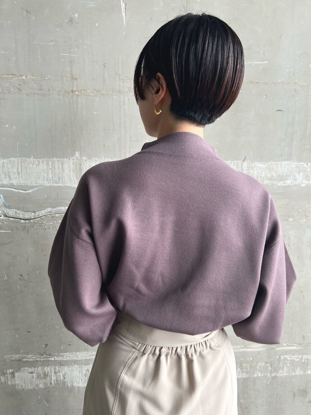 ホワイト系のノーカラーコート、ベージュ系のニット/セーター、ブラウン系のスカートを着用したレディースの秋コーディネートの8枚目の写真