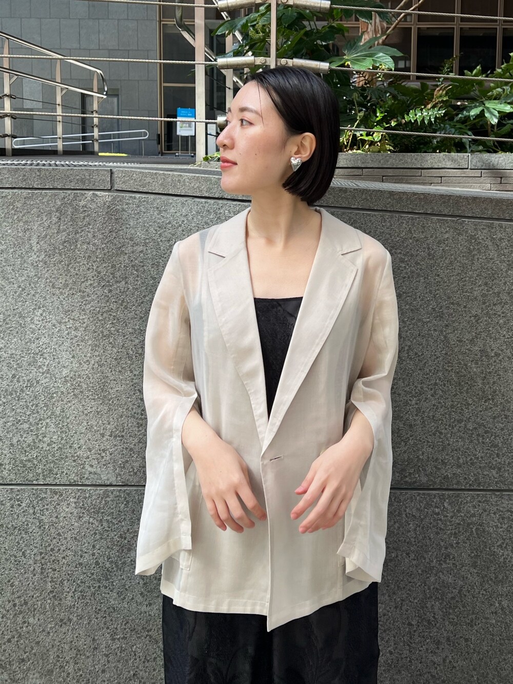 イエロー系のサンダル、ホワイト系のテーラードジャケット、ブラック系のつなぎ/オールインワンを着用したレディースの春コーディネートの3枚目の写真