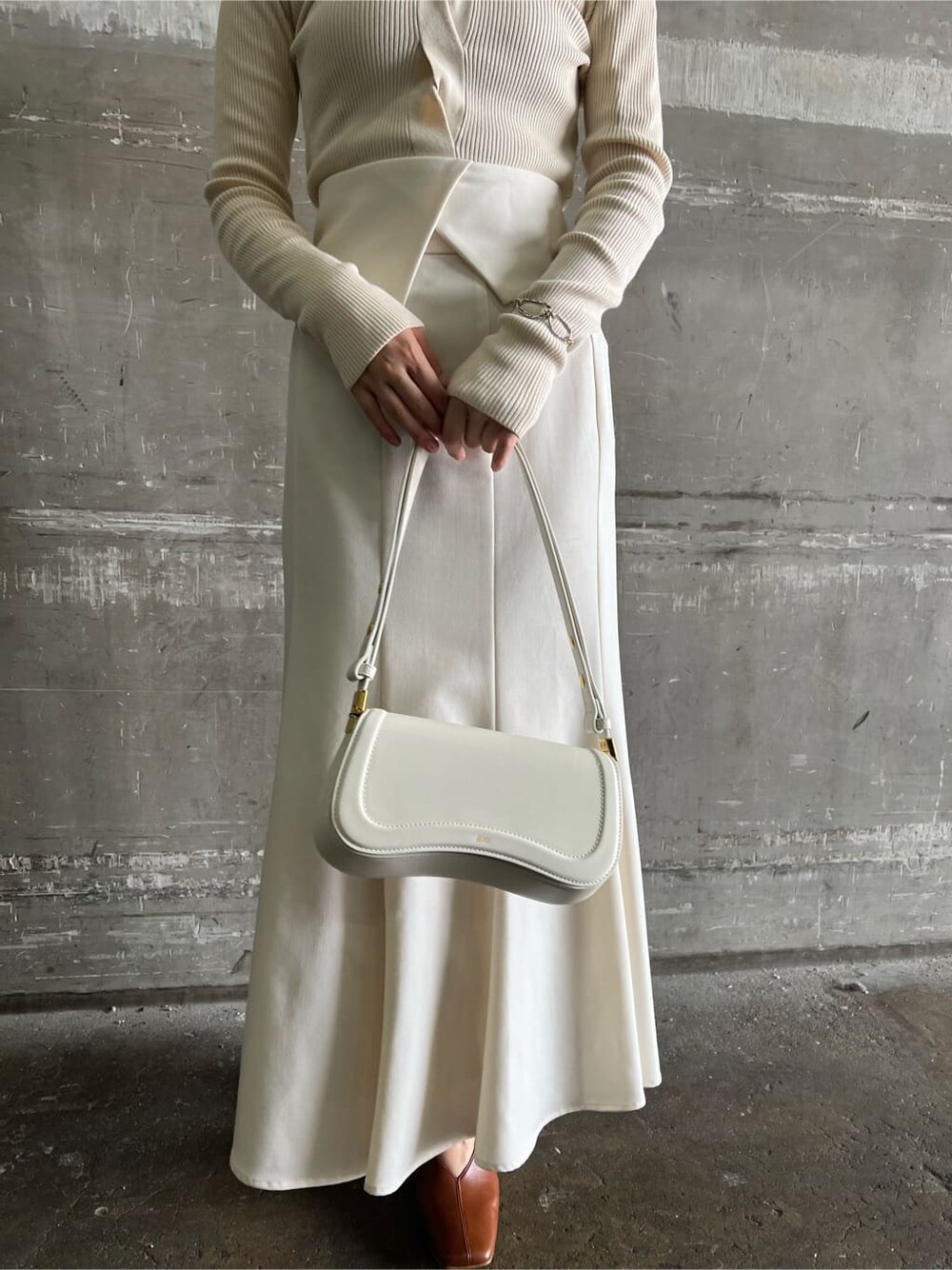 ブラウン系のパンプス、ホワイト系のスカート、ホワイト系のニット/セーターを着用したレディースの夏コーディネートの8枚目の写真