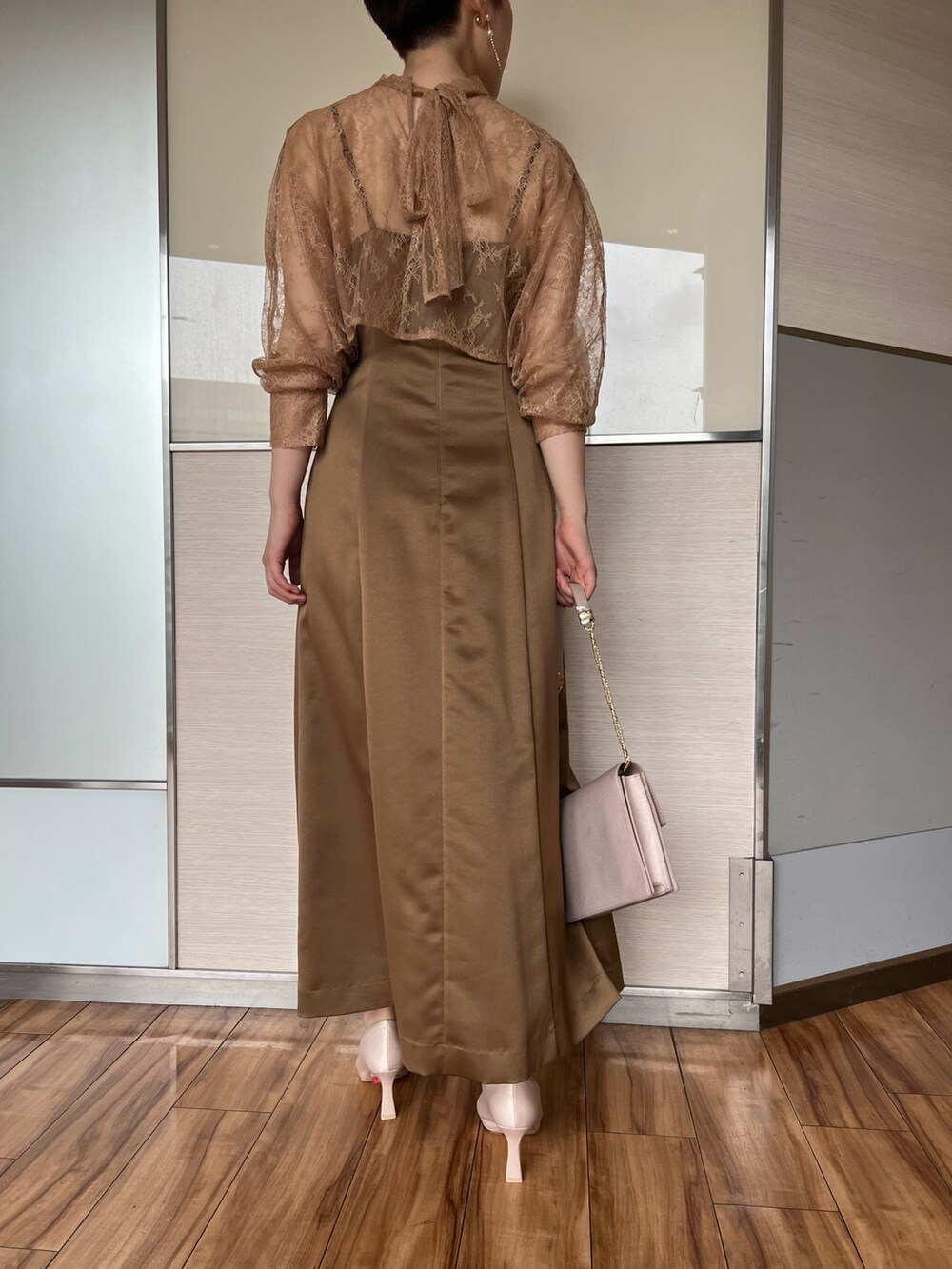 ベージュ系のクラッチバッグ、ブラウン系のドレス、ベージュ系のパンプスを着用したレディースの夏コーディネートの8枚目の写真
