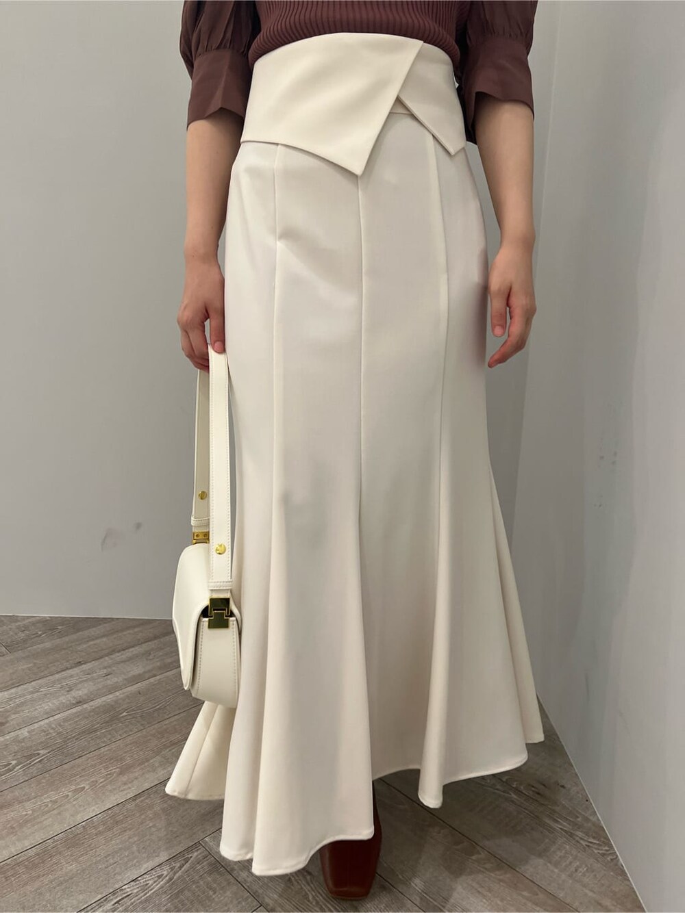 ブラウン系のパンプス、ホワイト系のスカート、ブラウン系のニット/セーターを着用したレディースの夏コーディネートの7枚目の写真