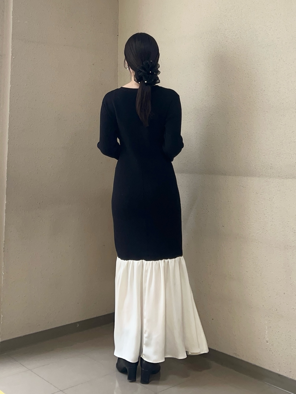 ブラック系のワンピース、ブラック系のブーツを着用したレディースの冬コーディネートの3枚目の写真