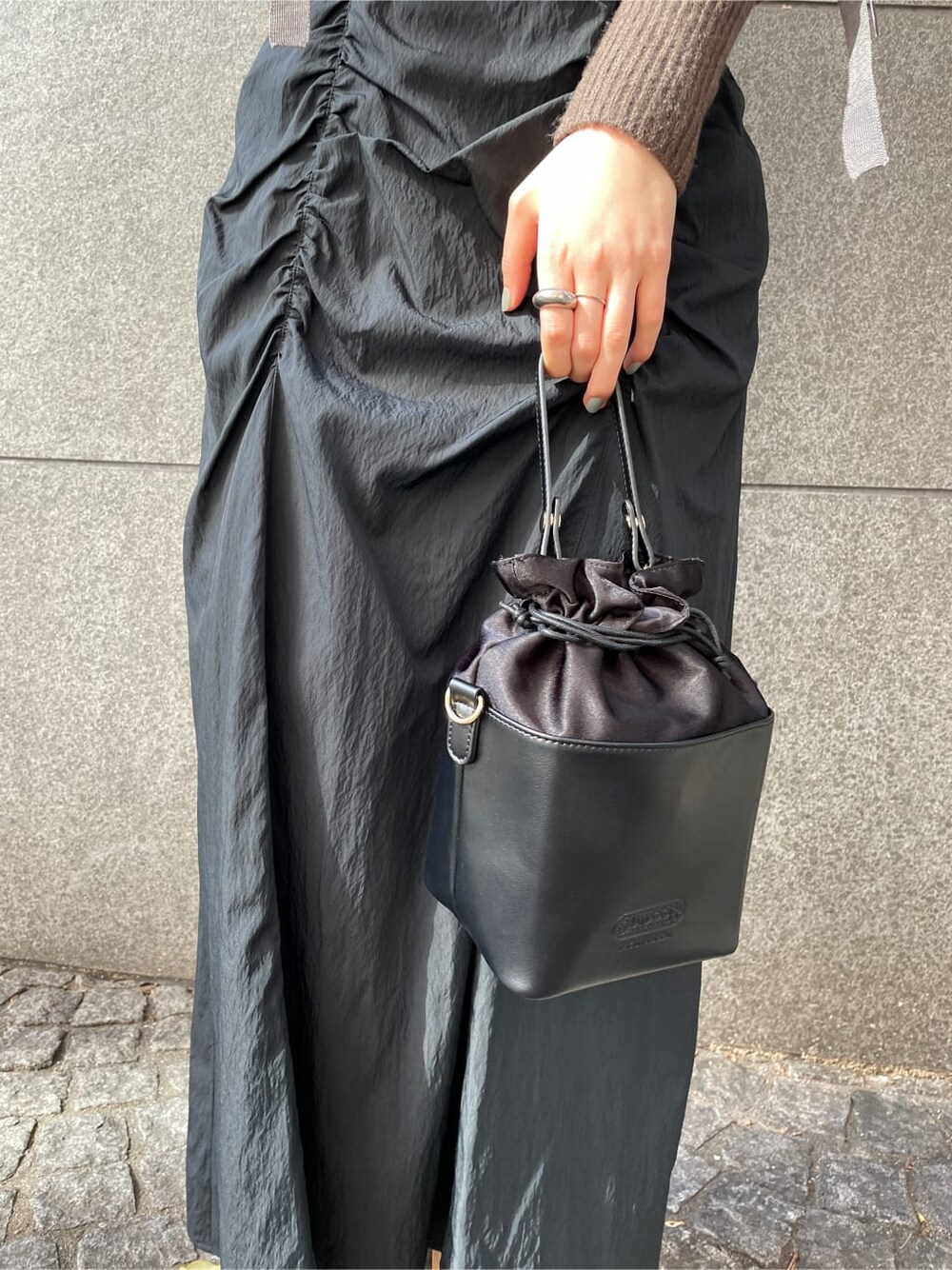 ベージュ系のその他シューズ、ホワイト系のその他アウター、ブラック系のスカートを着用したレディースの秋コーディネートの8枚目の写真