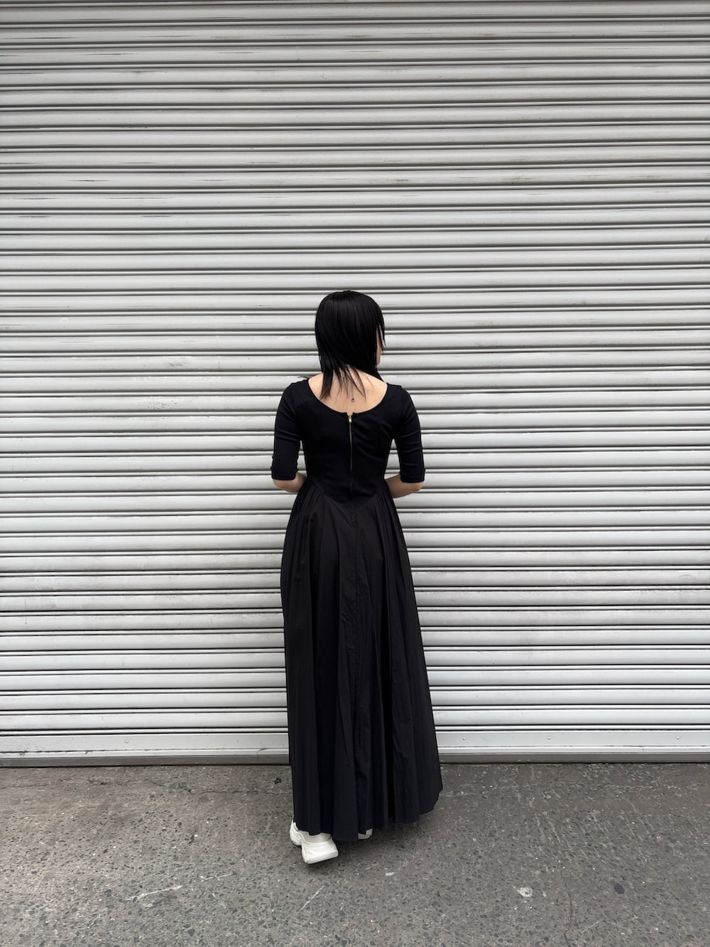 ブラック系のワンピース、ブルー系のテーラードジャケット、グレー系のスニーカーを着用したレディースの冬コーディネートの7枚目の写真