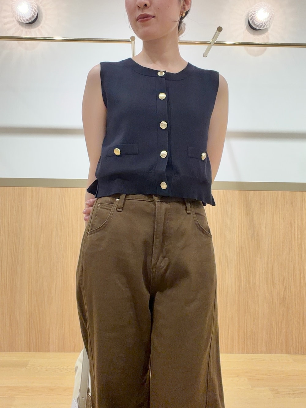 ブルー系のニット/セーター、ブラウン系のデニムパンツ、オレンジ系のサンダルを着用したレディースの夏コーディネートの5枚目の写真