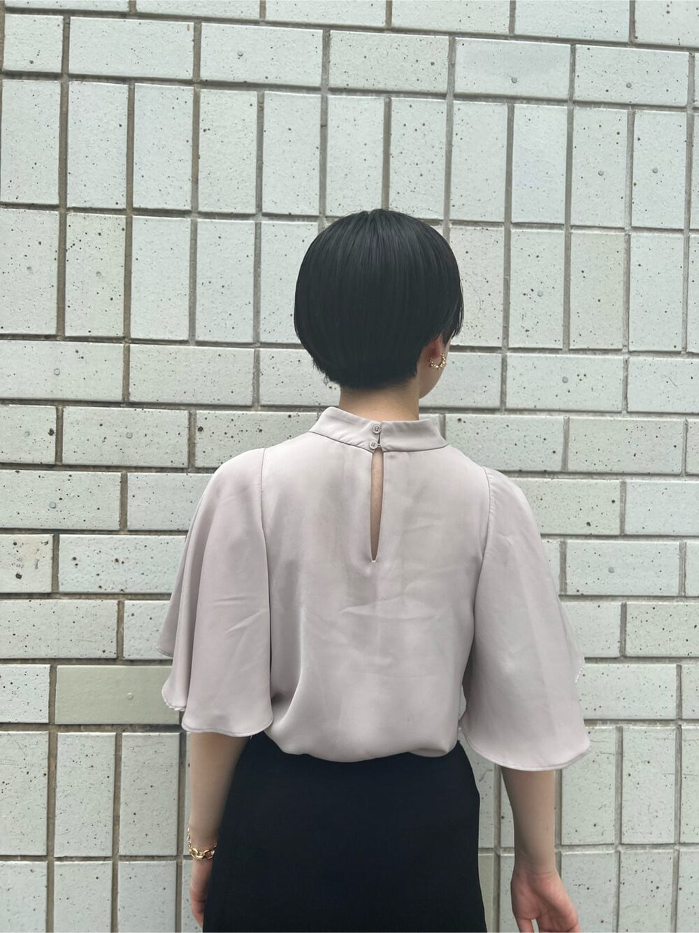 ベージュ系のハンドバッグ、グリーン系のサンダル、ブラック系のスカートを着用したレディースの夏コーディネートの6枚目の写真