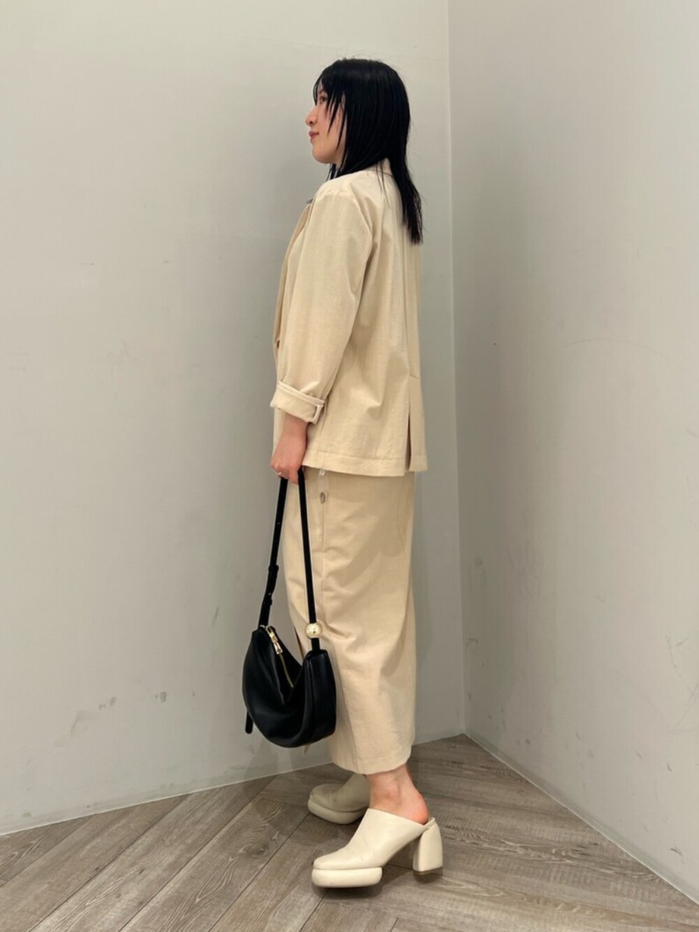 ブルー系のニット/セーター、ホワイト系のサンダル、ベージュ系のテーラードジャケットを着用したレディースの春コーディネートの2枚目の写真