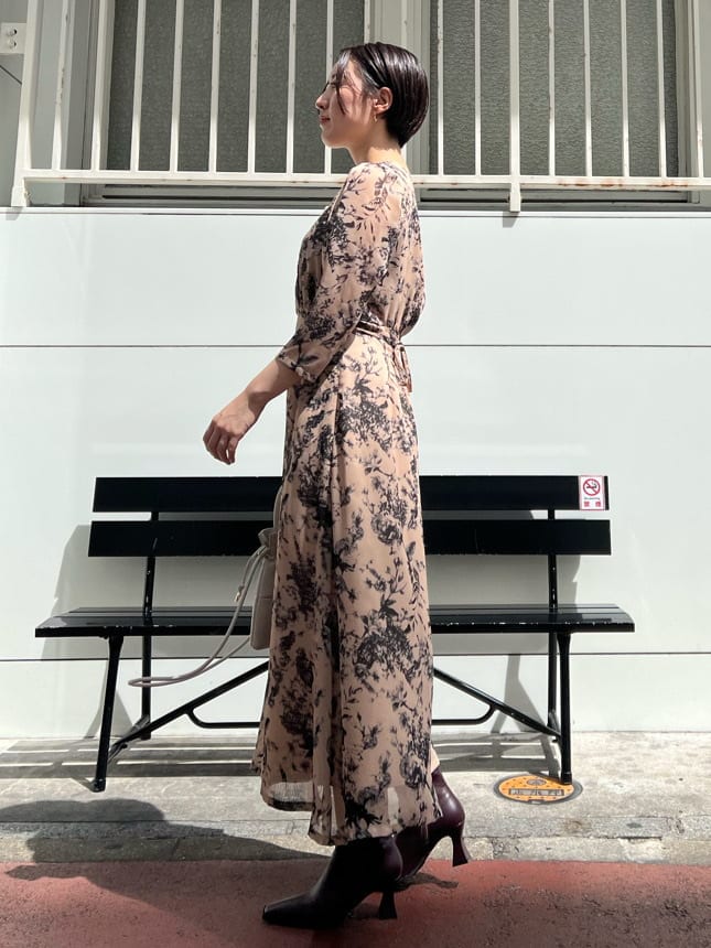 レッド系のブーツ、ホワイト系のカーディガン/ボレロ、ホワイト系のハンドバッグを着用したレディースの秋コーディネートの6枚目の写真