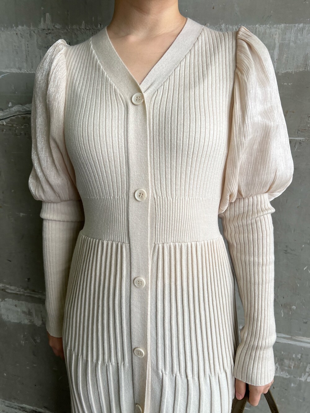 ベージュ系のブーツ、ホワイト系のワンピース、ベージュ系のハンドバッグを着用したレディースの冬コーディネートの3枚目の写真