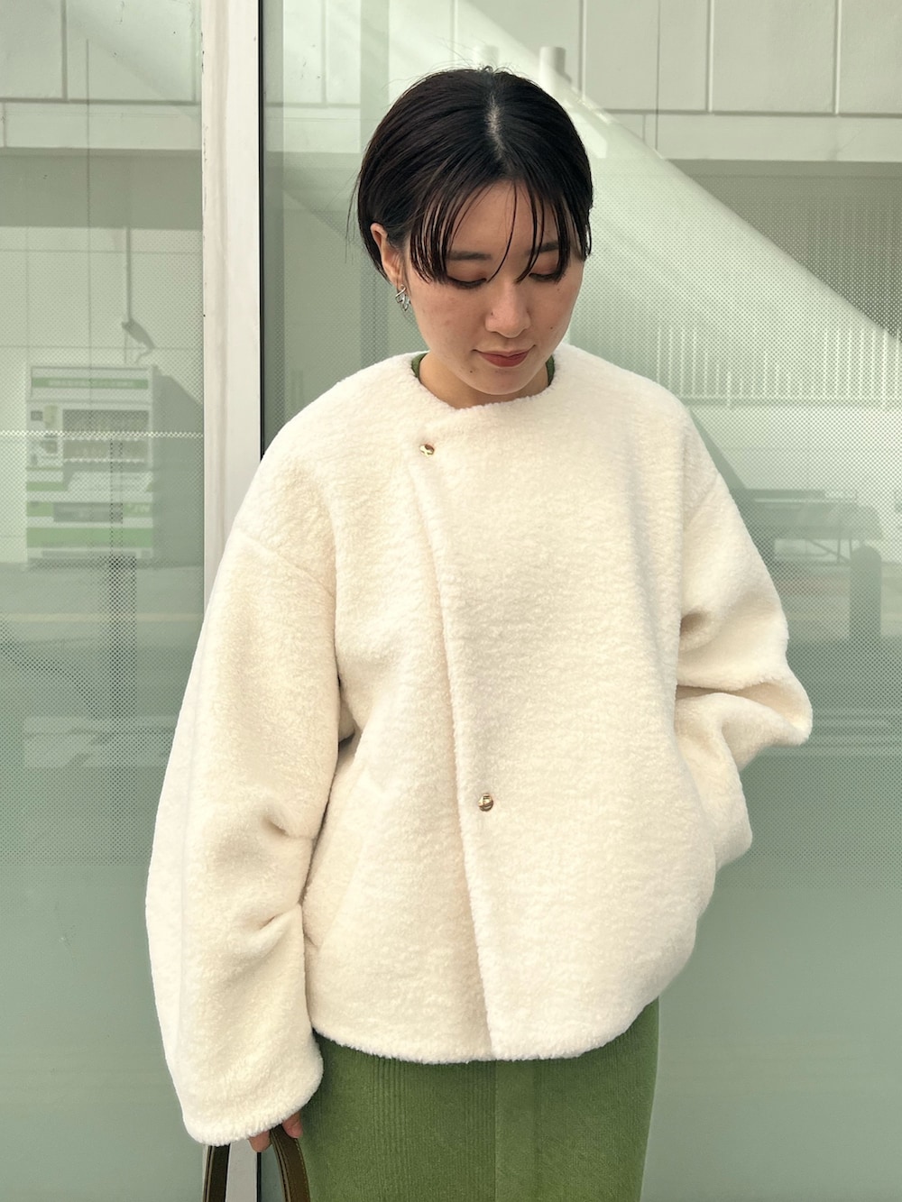 ブラウン系のショルダーバッグ、ベージュ系のブーツ、グリーン系のワンピースを着用したレディースの秋コーディネートの4枚目の写真